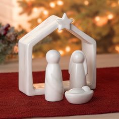 a small white nativity scene with a star