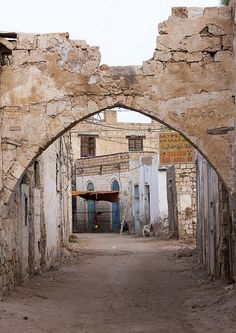 an arch in the middle of a dirt road