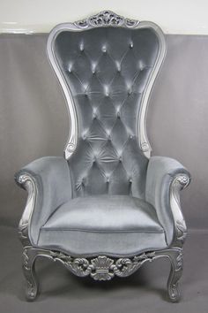 an old fashioned chair with silver velvet upholstered