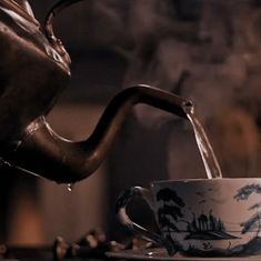 a tea pot pouring water into a cup