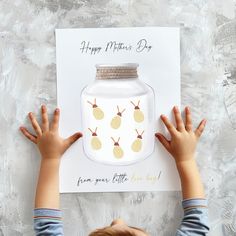 a young boy holding up a card with pineapples on it and the words happy mother's day