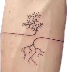 a small tree on the side of a woman's arm with roots growing out of it