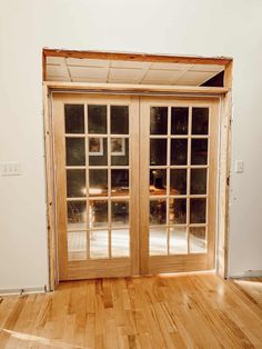 an empty room with wooden floors and sliding glass doors