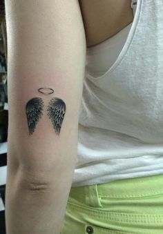 an angel wing tattoo on the arm