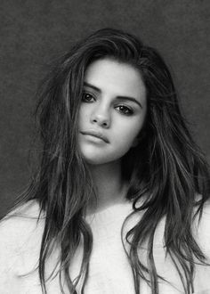 a black and white photo of a young woman with long hair, wearing a sweater