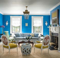 a living room with blue walls and white furniture in it's centerpieces