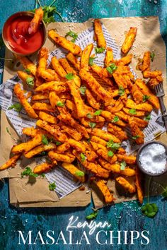 Masala chips on brown paper with tomato sauce and a small pot of salt. Masala Chips, Oven Chips, Vegetable Curry Recipes, Kenyan Food, Masala Fries, Curry Recipes Easy, Potato Slices, Masala Sauce, Garlic And Ginger