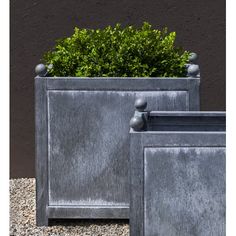 two metal planters sitting next to each other