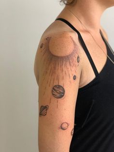 a woman's arm with planets and sun on it