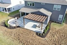 an aerial view of a house with a covered patio and pergolated deck in the foreground