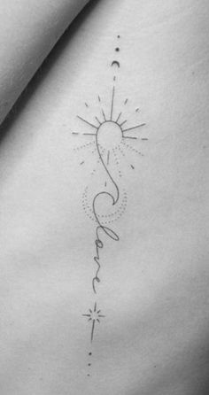 the back of a woman's stomach with a sun and stars tattoo on it