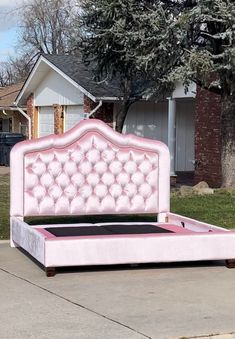 a pink bed sitting on top of a sidewalk