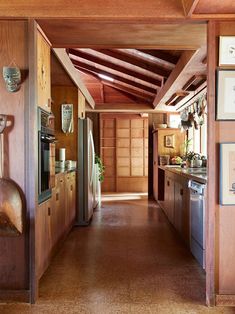 a long narrow kitchen with wood paneling on the walls and ceiling, along with wooden cabinets