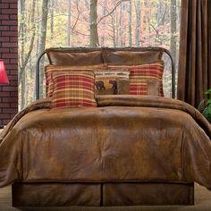 a bed in a room with a brown comforter and pillows on top of it