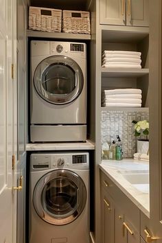 a washer and dryer in a small room with white towels on the shelves