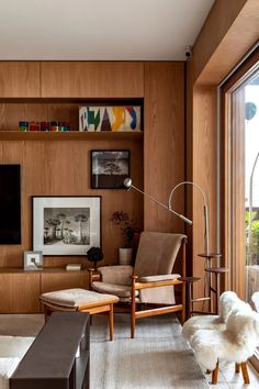 a living room filled with furniture and a flat screen tv mounted on a wall next to a window