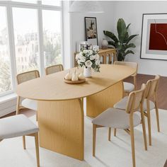 a dining room table with chairs and a vase filled with flowers on top of it