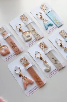 several pairs of earrings are displayed on cards