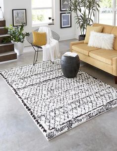 a living room with two couches and a rug on the floor in front of stairs