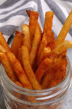 a jar filled with french fries sitting on top of a table