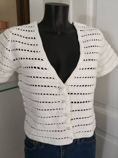 a mannequin wearing a white knitted cardigan