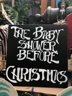 a sign that says the baby shower before christmas is displayed in front of other decorations