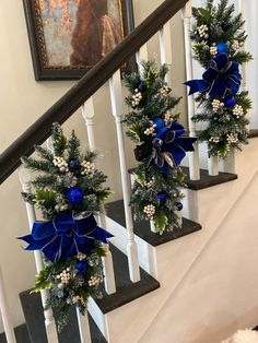 three christmas decorations on the banisters at the bottom of stairs in a home