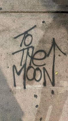 the word to the moon is written in black ink on concrete, next to a fire hydrant