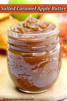 a jar filled with caramel apple butter sitting on top of a wooden cutting board