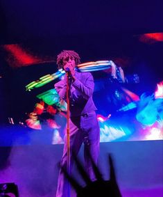 a man standing on top of a stage holding a microphone in front of his face