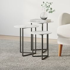 three white tables with black legs on carpeted floor next to chair and plant in vase