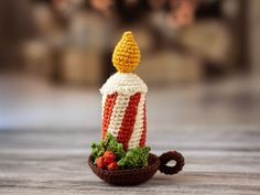 a crocheted candle is sitting on a table