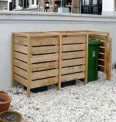 two wooden crates sitting next to each other on top of gravel covered ground in front of a building