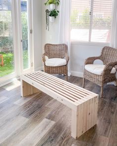 two wicker chairs and a wooden bench in a living room with sliding glass doors