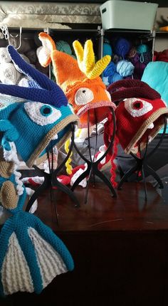 crocheted hats are on display in front of other knitted items and accessories