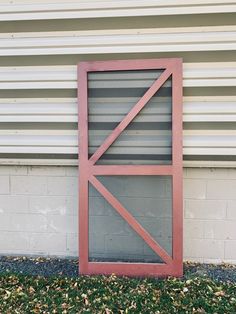 an open door on the side of a building in front of a brick wall and grass