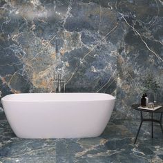 a white bath tub sitting on top of a marble floor