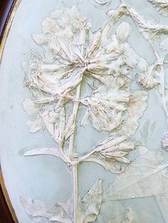 a close up of a flower on a plate with white frosting and brown trim