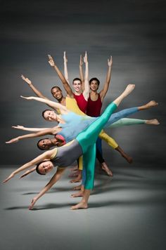 a group of people standing around each other with their arms in the air