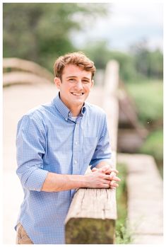 a man leaning on a wooden bench smiling at the camera