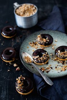 chocolate covered donuts on a plate with spoon