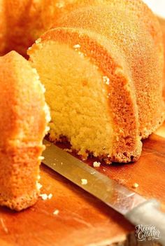 a bundt cake is cut into pieces on a wooden cutting board with a knife