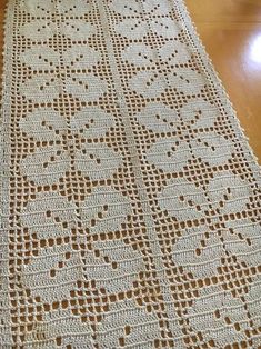 a white crocheted blanket sitting on top of a wooden floor