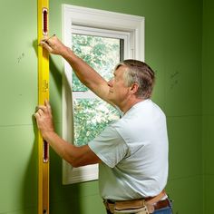 a man measuring the height of a window