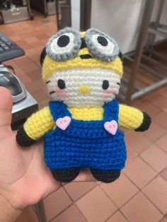 a crocheted minion is holding in someone's hand