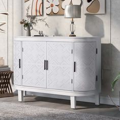 a white cabinet sitting next to a lamp on top of a wooden table in a living room