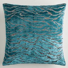 a teal pillow with silver sequins on it