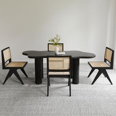 a black table with four chairs and a potted plant sitting on top of it