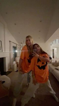 two women in orange shirts are posing for the camera