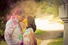 a man and woman kissing while covered in colored powder